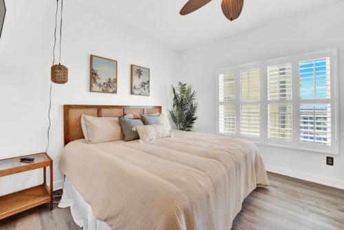 una camera bianca con un grande letto e finestre di Shores of Panama 804 a Panama City Beach