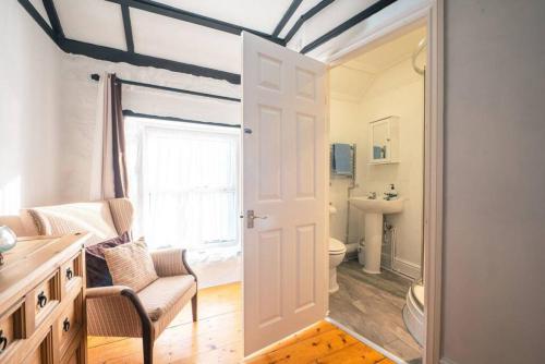 a bathroom with a toilet and a window and a door at Cosy Welsh Cottage in St Davids Centre with Garden in St. Davids