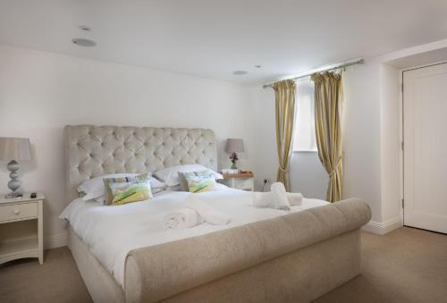a bedroom with a large white bed with towels on it at Rose Cottage - Gonwin Manor in Carbis Bay