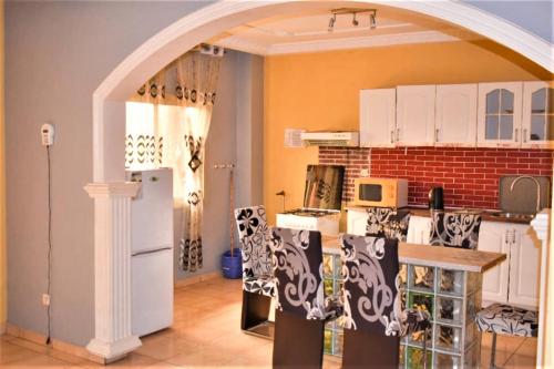 a kitchen with an archway and a white refrigerator at Résidence Hotelière Borel Denver in Douala