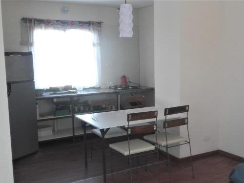 cocina con mesa, sillas y ventana en MADRESELVA en San Rafael