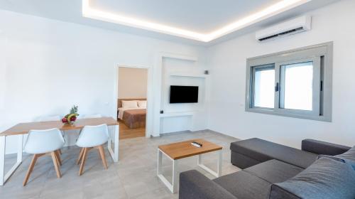 a living room with a couch and a table at Dias Luxury Homes in Koskinou