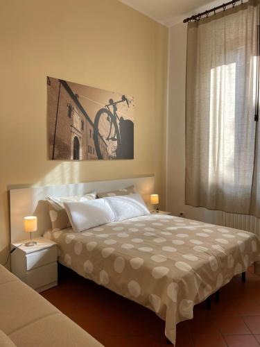 a bedroom with a bed with a bicycle painting on the wall at Downtown - Camere in Centro in Ferrara
