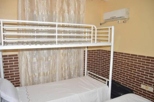 two bunk beds in a room with a brick wall at Résidence Hotelière Borel Denver in Douala