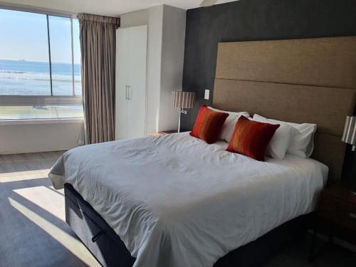 a large bed in a hotel room with a large window at Lovely Apartment in Milnerton in Cape Town