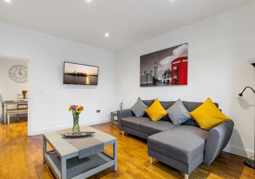 a living room with a couch and a table at Two Bed Flat in Bush Hill Park in Enfield