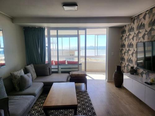 a living room with a couch and a table at Lovely Apartment in Milnerton in Cape Town