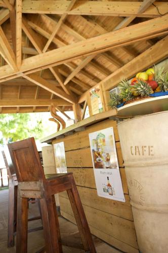 a wooden counter with a wooden chair and a table at Hotel Le Recif, Ile de la Reunion in Saint-Gilles les Bains