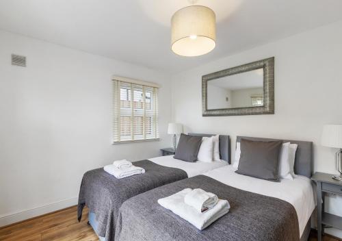 two beds in a bedroom with a mirror at Two Bed Flat in Bush Hill Park in Enfield