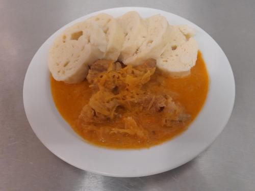 a white plate with a bowl of soup with bread at Pension Jana - Wellness in Jilemnice