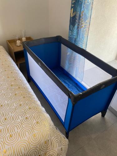 einem blauen Bettrahmen in einem Zimmer mit einem Tisch in der Unterkunft Lovely flat border to Monaco- private parking - sea view and terrace in Beausoleil