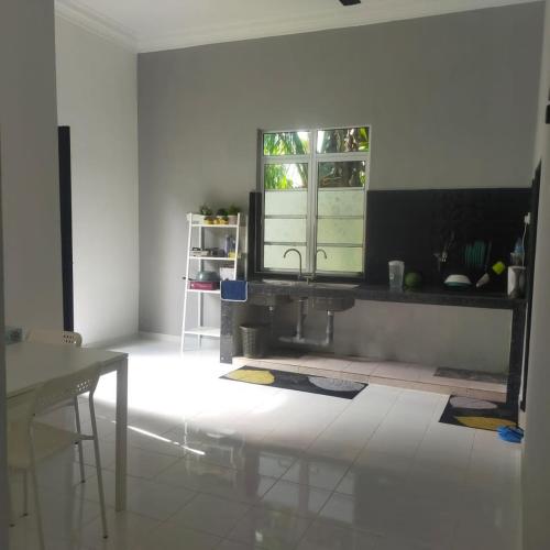 uma sala de estar com um lavatório e uma janela em Homestay ainnor em Pasir Puteh
