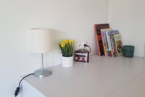 a table with a lamp and books on it at Studio 2 lits jumeaux 1 station Tram aéroport Orly in Athis-Mons