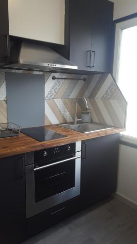 a kitchen with a stove and a sink at Studio 2 lits jumeaux 1 station Tram aéroport Orly in Athis-Mons