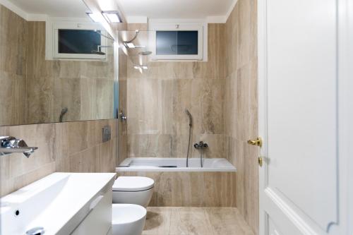 łazienka z toaletą, umywalką i wanną w obiekcie Montenapoleone - Sant Andrea Charme PentHouse w Mediolanie