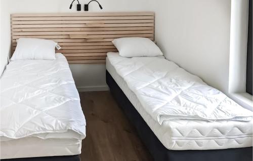 two beds in a room with white sheets and pillows at Pet Friendly Ship In Kruklanki With Lake View in Kruklanki