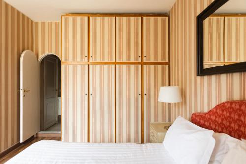 sypialnia z łóżkiem i dużą szafą w obiekcie Montenapoleone - Sant Andrea Charme PentHouse w Mediolanie