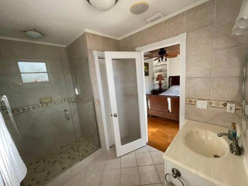 a bathroom with a sink and a shower and a bed at The perfect Gulfport Fl Getaway! in St. Petersburg