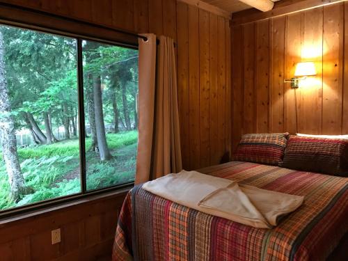 een slaapkamer met een bed en een groot raam bij Covewood Lodge 