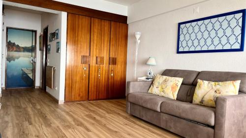 a living room with a couch and a wooden door at Sun & Sea 509 in Sesimbra