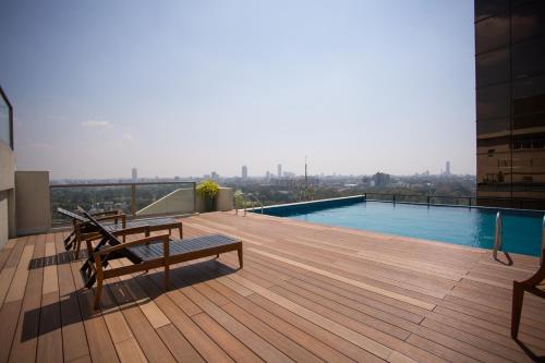 a deck with benches and a swimming pool on a building at Niwahas Apartment Borella in Colombo