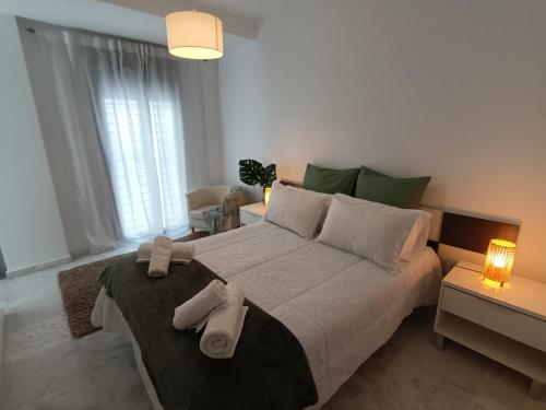 1 dormitorio con 1 cama grande y toallas. en Casa Palacio Arcos del Carmen, en Jerez de la Frontera