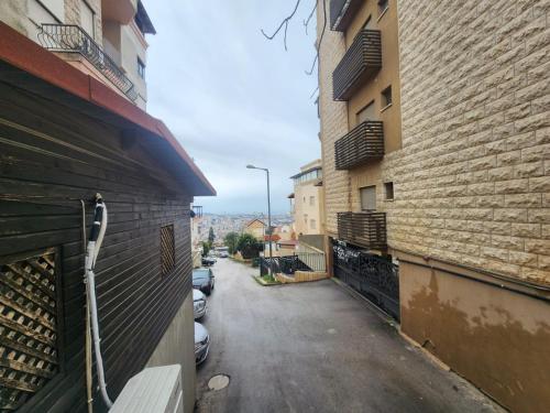 eine Gasse zwischen zwei Gebäuden mit parkenden Autos in der Unterkunft סבתא פיירוז-Grandma Fairoz in Nazareth