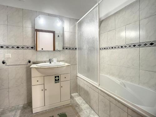 un bagno bianco con lavandino e doccia di Milagres Apartment by Atlantic Holiday a Machico