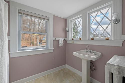 a bathroom with a sink and two windows at The Hartness House in Springfield