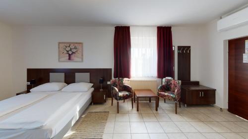 pokój hotelowy z łóżkiem, stołem i krzesłami w obiekcie Hotel San Marco w mieście Lannach