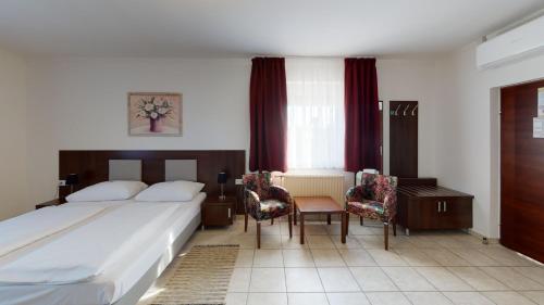 a hotel room with a bed and a table and chairs at Hotel San Marco in Lannach