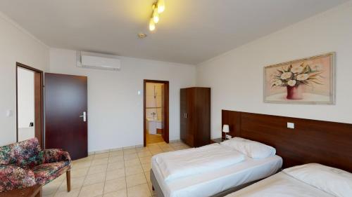a hotel room with a bed and a chair at Hotel San Marco in Lannach