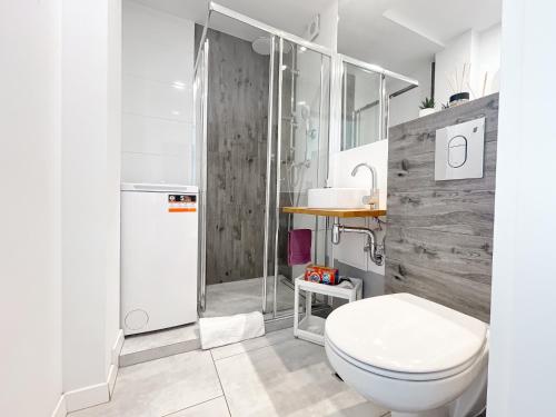 a bathroom with a toilet and a shower and a sink at COCO Apartments Jagiellońska 10 in Gdańsk