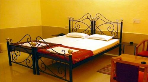 een slaapkamer met een bed met een zwart metalen frame bij Ocean Glass in Baga