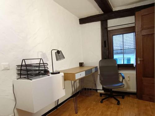 a desk and a chair in a room with a window at Downtown Switzerland/Bodensee/Zurich in Ermatingen