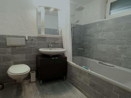 La salle de bains est pourvue de toilettes, d'un lavabo et d'une baignoire. dans l'établissement Downtown Switzerland/Bodensee/Zurich, à Ermatingen