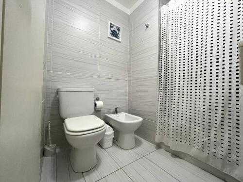 Baño blanco con aseo y lavamanos en Deluxe apartment in great location en Buenos Aires