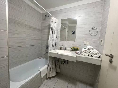 Baño blanco con bañera y lavamanos en Deluxe apartment in great location en Buenos Aires