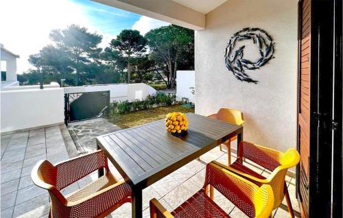 Una mesa y sillas de madera en un patio. en Lovely Home In Baia S Anna Budoni, en Tanaunella