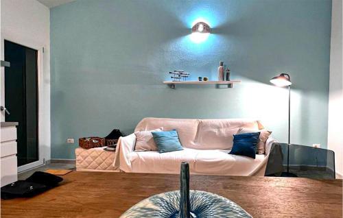 sala de estar con sofá blanco y pared azul en Lovely Home In Baia S Anna Budoni, en Tanaunella