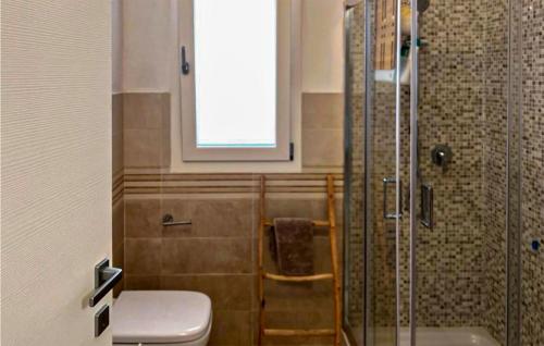 La salle de bains est pourvue d'une douche, de toilettes et d'une fenêtre. dans l'établissement 1 Bedroom Stunning Home In Baia S, Anna Budoni, à Tanaunella