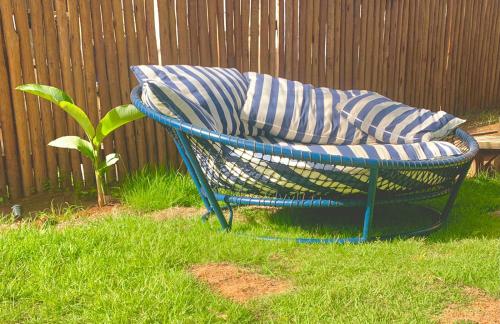a blue chair sitting in the grass in a yard at Villa Xodó in Fernando de Noronha