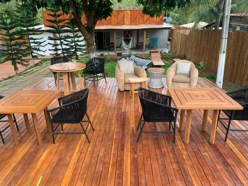 a group of tables and chairs on a wooden deck at Villa Xodó in Fernando de Noronha