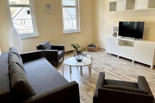 ein Wohnzimmer mit Sofa und Fernseher in der Unterkunft Ferienwohnung Alte Schule 4 "Hermann Lietz" in Mellenbach-Glasbach