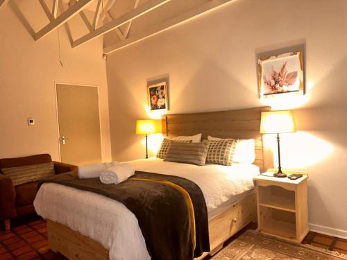 um quarto com uma cama grande e 2 candeeiros em WOODS GUEST HOUSE em Middelburg