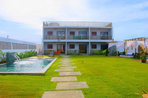 a building with a yard with a swimming pool at Pousada Sal e Sol in São Miguel do Gostoso