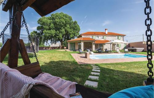 a swing in front of a house with a pool at Cozy Home In Sajini With Outdoor Swimming Pool in Šajini