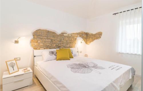 a bedroom with a large bed with a stone wall at Cozy Home In Sajini With Outdoor Swimming Pool in Šajini