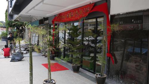 a store front with potted plants in front of it at Dream Garden Hotel in Klang