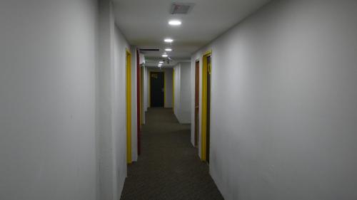 a hallway with white walls and yellow doors at Dream Garden Hotel in Klang